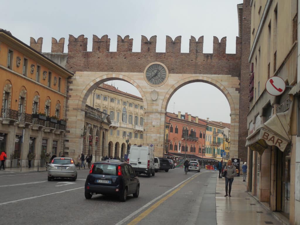 Verkehr in Verona in der Innenstadt, schön zu sehen ist die Porta mit der Uhr