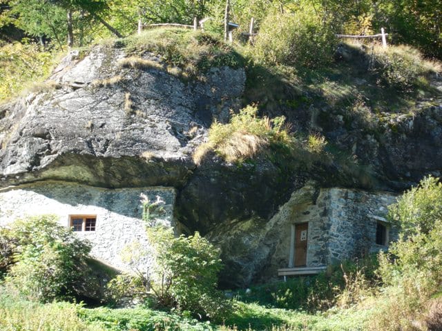 Eine Felsenhaus überwachsen mit Gras und Moos