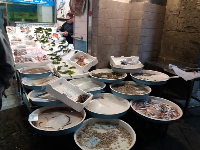 Fischverkäufer in Neapel mit seiner Ware in Plastikbehältern
