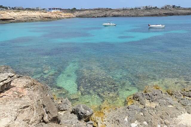 Lampedusa mit ihrer typischen kargen Vegetation und dem blaugrünen Meer