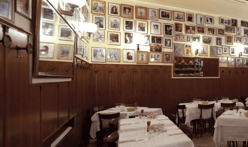 Die Wände sind mit Fotos von berühmten Personen getafelt, die hier aßen, davor gedeckte Tische