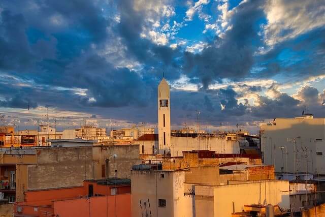 Sonnenuntergang in Barletta mit Sicht auf die Dächer der Stadt und dem Kirchturm